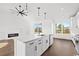 Modern kitchen featuring stainless appliances, white cabinets, quartz countertops, and adjacent living area at 163 Sago Palm Dr., Myrtle Beach, SC 29579