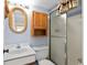 Bathroom with a walk-in shower and a traditional wood cabinet and a wicker mirror at 1709 S Ocean Blvd. S # 205, North Myrtle Beach, SC 29582