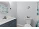 Bathroom featuring a blue vanity, round mirror, toilet, and a shower with a patterned curtain at 1890 Colony Dr. # 17S, Myrtle Beach, SC 29575