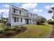A two-story townhome with a well-maintained lawn and landscaping and neutral exterior paint and black shutters at 1890 Colony Dr. # 17S, Myrtle Beach, SC 29575