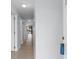 Long hallway with neutral tile flooring leads to a screened in porch with backyard views at 1890 Colony Dr. # 17S, Myrtle Beach, SC 29575