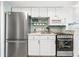 Compact kitchen featuring white cabinets, stainless steel appliances, and tiled backsplash at 2001 S Ocean Blvd. # 210, Myrtle Beach, SC 29577