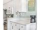 Well-lit kitchen with white cabinets, marble countertops, and modern coffee machine at 2001 S Ocean Blvd. # 210, Myrtle Beach, SC 29577