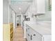 Bright galley kitchen with white cabinets, modern appliances, and a view down the hall at 2001 S Ocean Blvd. # 210, Myrtle Beach, SC 29577