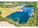 Expansive aerial view showcasing a large pond surrounded by lush greenery with a residence nearby at 2300 Tansy Rd., Loris, SC 29569