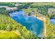 Picturesque aerial view of a large pond surrounded by lush trees and a residence with a private pond at 2300 Tansy Rd., Loris, SC 29569