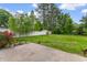 Large, well-maintained backyard with mature trees, a white fence, and a concrete patio at 2446 Farmwood Circle, Conway, SC 29527