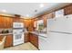 Functional kitchen with wooden cabinets, white appliances, and tile flooring at 2446 Farmwood Circle, Conway, SC 29527