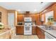 Functional kitchen with wooden cabinets, white appliances, and tile flooring at 2446 Farmwood Circle, Conway, SC 29527