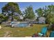 Backyard with an above-ground pool, lush green grass, mature trees, and patio furniture at 2703 Canvasback Trail, Myrtle Beach, SC 29588