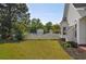 Spacious backyard with a white picket fence surrounding the in-ground pool and mature landscaping at 2703 Canvasback Trail, Myrtle Beach, SC 29588