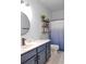 Stylish bathroom featuring navy vanity, a round mirror and a shower with a blue ombre curtain at 2703 Canvasback Trail, Myrtle Beach, SC 29588