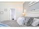 A cozy bedroom featuring soft gray bedding and a view into the ensuite bathroom at 2703 Canvasback Trail, Myrtle Beach, SC 29588