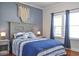 Bedroom featuring a gray paneled headboard with blue and white bedding, next to a window with blue drapes at 2703 Canvasback Trail, Myrtle Beach, SC 29588