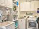 Functional laundry room with white cabinets, shelving, modern appliances, and organized storage solutions at 2703 Canvasback Trail, Myrtle Beach, SC 29588