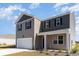 The exterior showcases a two-car garage, complemented by a welcoming entrance, and cozy front porch at 2892 Riverboat Way, Conway, SC 29526