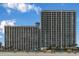 Oceanfront condo buildings with views of the beach with blue skies and lounge chairs at 3000 N Ocean Blvd. # 1020, Myrtle Beach, SC 29577
