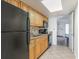 Functional kitchen with wood cabinets, black appliances, and tiled flooring at 3000 N Ocean Blvd. # 1020, Myrtle Beach, SC 29577