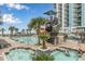 Resort-style pool with slides, a spiral staircase, and a hot tub, surrounded by lush landscaping and palm trees at 3000 N Ocean Blvd. # 1020, Myrtle Beach, SC 29577