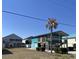 Exterior view of an elevated teal house with a palm tree at 317 29Th Ave. N, North Myrtle Beach, SC 29582