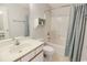 Bright bathroom featuring a vanity sink, toilet, and shower with blue curtain at 3170 Holmestown Rd., Myrtle Beach, SC 29588