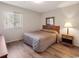 Cozy bedroom featuring a comfortable bed, wooden floors, natural light from the window, and a bedside table with lamp at 3170 Holmestown Rd., Myrtle Beach, SC 29588