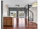 Inviting living room boasts wood floors, a spiral staircase, and balcony views of the outdoor pool at 3700 Golf Colony Lane # 5J, Little River, SC 29566