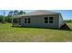 Spacious backyard with green grass and large windows showcasing the home's natural light at 4488 East Coast Ln., Shallotte, NC 28470