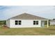 Exterior shot of the home showing the vinyl siding and expansive backyard with green grass at 4496 East Coast Ln., Shallotte, NC 28470