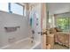 Bathroom with bathtub, shower, window, and view into bedroom at 4601 Greenbriar Dr. # 201, Little River, SC 29566