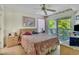 Comfortable bedroom with ceiling fan and private balcony overlooking lush greenery at 4601 Greenbriar Dr. # 201, Little River, SC 29566