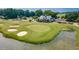 Aerial shot of a scenic golf course with sand traps, a green, water feature, and clubhouse at 4601 Greenbriar Dr. # 201, Little River, SC 29566