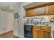 Kitchen with wood cabinets, a sink, and a black dishwasher ready for easy clean up at 4601 Greenbriar Dr. # 201, Little River, SC 29566