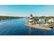 Scenic aerial view featuring a black and white lighthouse, pool, waterway, and docked boats at 4601 Greenbriar Dr. # 201, Little River, SC 29566