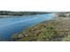 Aerial view of boat cruising down the waterway surrounded by marsh grasses and trees at 4601 Greenbriar Dr. # 201, Little River, SC 29566