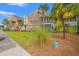 Brick condo exterior featuring lush landscaping, a screened patio, and mature palm trees at 4648 Fringetree Dr. # C, Murrells Inlet, SC 29576