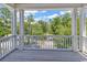 This balcony features white pillars and railings with views of green trees and a peek of the sky at 48 Half Shell Ct., Litchfield, SC 29585
