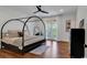 Bright bedroom featuring a canopy bed, natural light, and balcony doors with view of trees and outdoor scenery at 48 Half Shell Ct., Litchfield, SC 29585