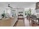 Bright living room featuring a ceiling fan, hardwood floors, and large windows at 48 Half Shell Ct., Litchfield, SC 29585