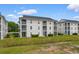 Apartment building featuring private balconies on each level, surrounded by well-maintained greenery and blue skies at 480 River Oaks Dr. # 63-O, Myrtle Beach, SC 29579