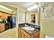 Well-lit bathroom with wood cabinets, a mirror, and an integrated sink and counter at 504 N Ocean Blvd. # 1810, Myrtle Beach, SC 29577