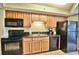 Well-equipped kitchen with black appliances, granite countertops, and wooden cabinetry at 504 N Ocean Blvd. # 1810, Myrtle Beach, SC 29577