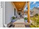 Inviting front porch with wood columns, ceiling fan, cozy seating, and brick steps leading to the entry at 5049 Middleton View Dr., Myrtle Beach, SC 29579