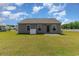 Backyard view of home with a manicured lawn, neutral siding, and small patio area at 509 Wildfire Ct., Longs, SC 29568
