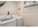 Functional laundry room with modern white washer and dryer units and wire shelving for storage at 509 Wildfire Ct., Longs, SC 29568