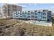 Aerial view of condo building near the dunes and beach with outdoor pool, walkways and direct beach access at 5600 Ocean Blvd. N # A11, North Myrtle Beach, SC 29582