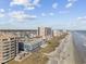 Coastal aerial of beachfront condos with a pier and beach goers on the shoreline at 5600 Ocean Blvd. N # A11, North Myrtle Beach, SC 29582