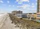 Panoramic view of beachfront condos along a sandy shore, adjacent to the beach, on a sunny day at 5600 Ocean Blvd. N # A11, North Myrtle Beach, SC 29582