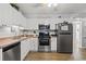 Well-lit kitchen featuring stainless steel appliances, white cabinets, and laminate wood-style flooring at 5600 Ocean Blvd. N # A11, North Myrtle Beach, SC 29582