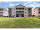 Exterior view of a multi-story building with screened-in patios and manicured lawn at 619 Waterway Village Blvd. # 7C, Myrtle Beach, SC 29579